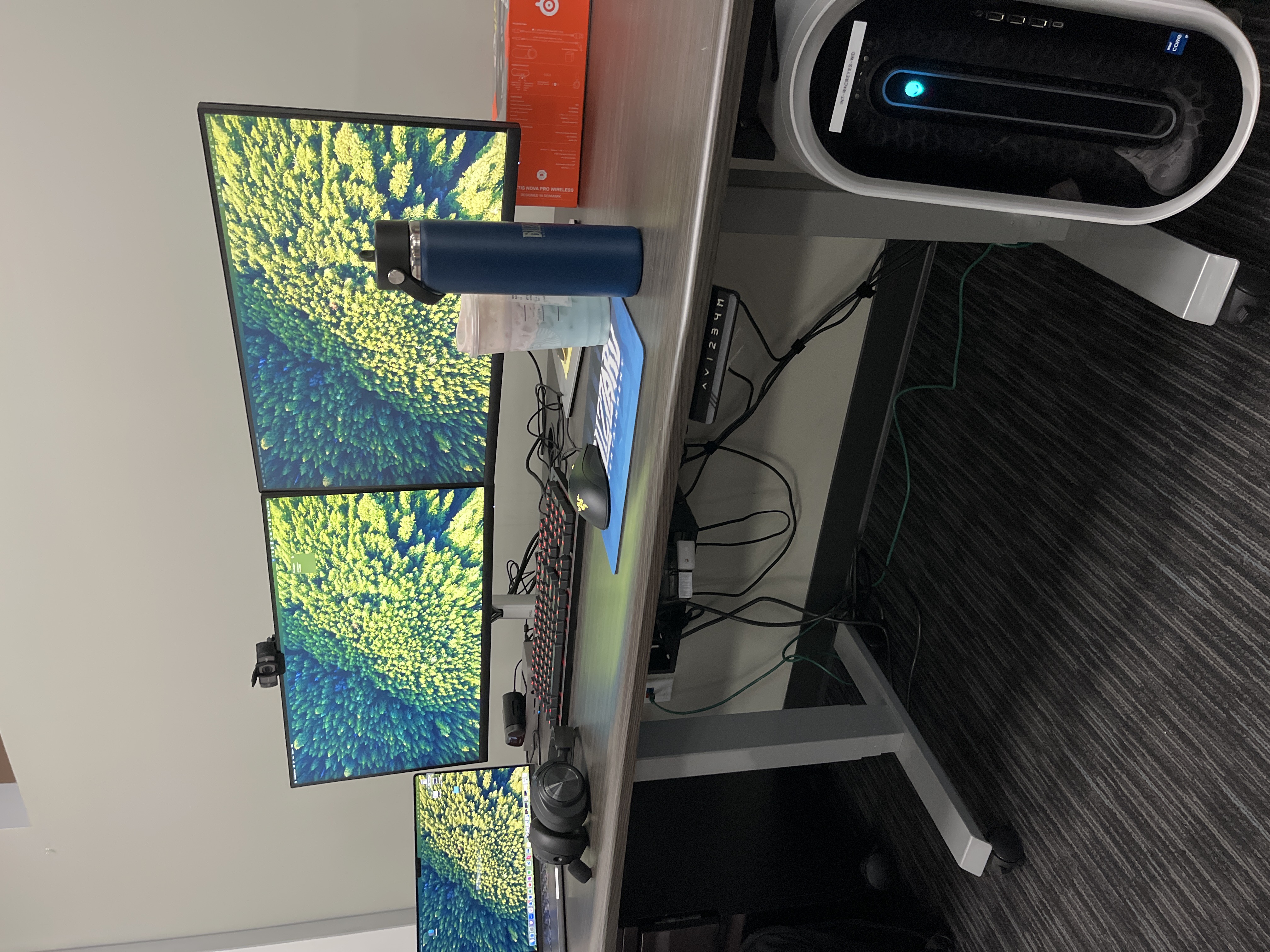 Two monitors side by side with a Mac laptop on the left and an Alienware desktop on the right